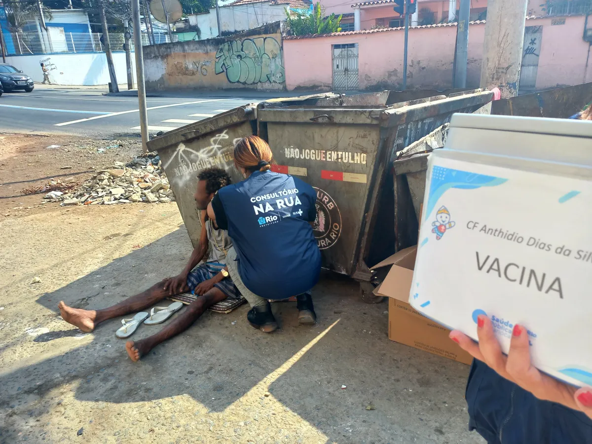 Profissional do Consultório na Rua realizando atendimento próximo a materiais de vacinação.